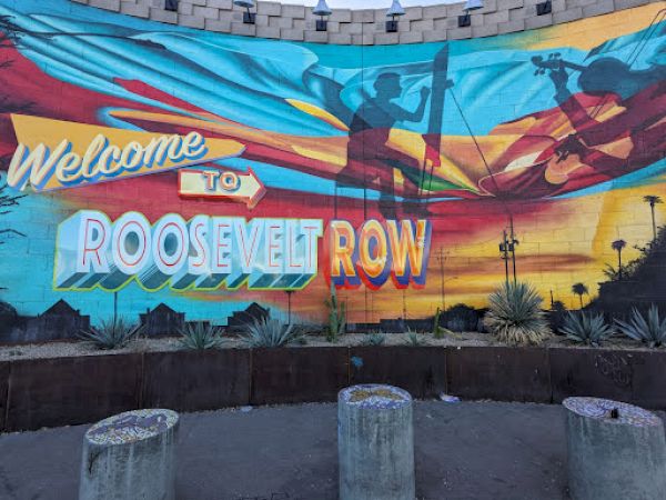 A colorful mural with "Welcome to Roosevelt Row," featuring artistic silhouettes and desert plants in the foreground.